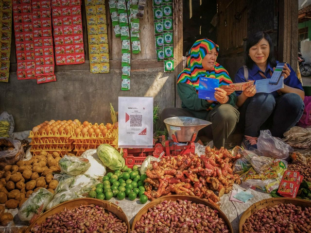 Pelaku UMKM menyetorkan tabungan ke petugas BRI. Foto: Dok. BRI