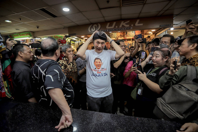 Bakal Calon Gubernur DKI Jakarta dari Partai Golkar Jusuf Hamka mengenakan blangkon yang dibeli di pedagang saat melakukan blusukan di Blok A Pasar Tanah Abang, Jakarta, Kamis (1/8/2024). Foto: Jamal Ramadhan/kumparan