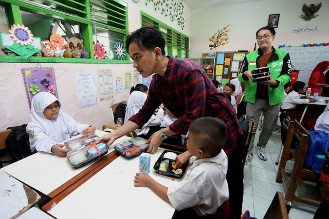 Wakil Presiden terpilih Gibran Rakabuming Raka (tengah) membagikan paket makanan saat meninjau uji coba pelaksanaan program makan bergizi gratis di SD Negeri Klampis Ngasem 3, Surabaya, Jawa Timur, Kamis (1/8/2024). Foto: Moch Asim/ANTARA FOTO 