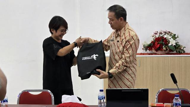 Kepala Kantor Imigrasi Kelas I TPI Manado, Rachmat, menerima cenderamata dari Direktur Kajian Strategis Kementerian Pariwisata dan Ekonomi Kreatif (Kemenparekraf), Agustini Rahayu.