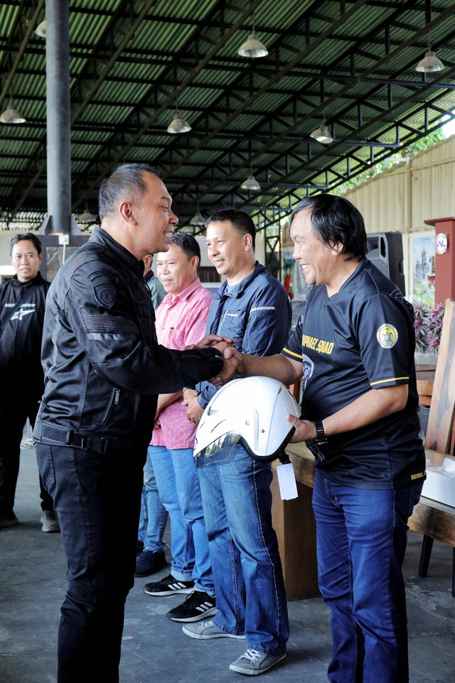 Dirut Jasa Raharja Rivan A. Purwantono menyerahkan helm kepada komunitas NMax Tomohon pada kegiatan safety riding dalam meningkatkan kesadara berlalu lintas. Foto: Dok. Istimewa