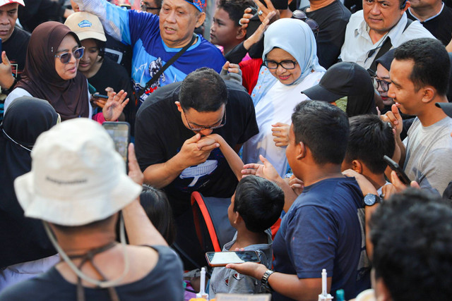 Mantan Gubernur DKI Jakarta Anies Baswedan menyapa warga saat car free day (CFD) di Kawasan Dukuh Atas, Jakarta, Minggu (8/4/2024). Foto: Iqbal Firdaus/kumparan