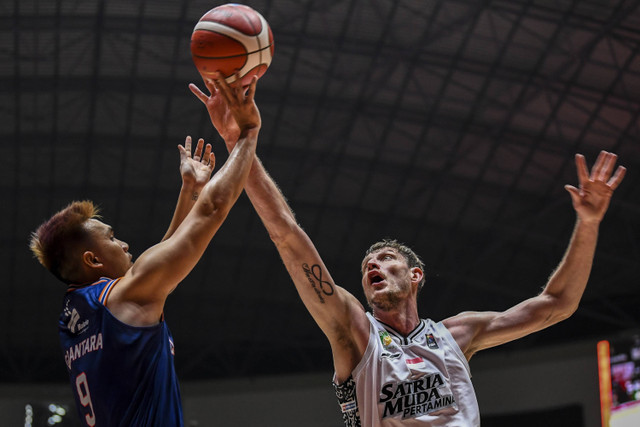 Pebasket Pelita Jaya Jakarta Agassi Yeshe Goantara berusaha melempar bola yang dihalangi pebasket Satria Muda Pertamina Jakarta Artem Pustovyi pada pertandingan final IBL 2024 di Indoor Stadium Sport Centre, Kabupaten Tangerang, Minggu (4/8/2024). Foto: Galih Pradipta/ANTARA FOTO