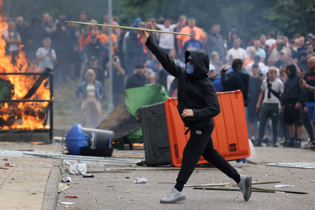 Pengunjuk rasa membakar tempat sampah di luar sebuah hotel di Rotherham, Inggris, Minggu (4/8/2024). Foto: Hollie Adams/REUTERS