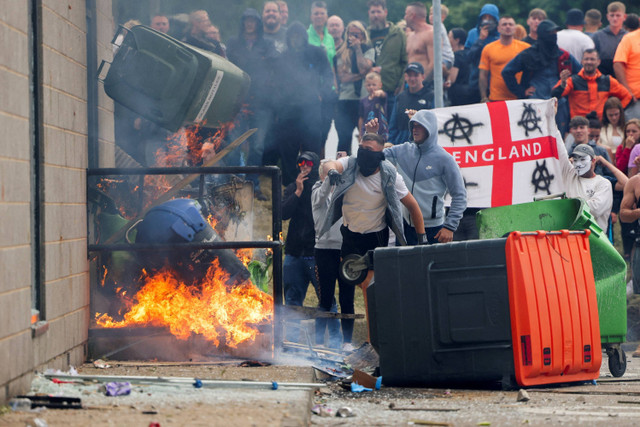 Pengunjuk rasa membakar tempat sampah di luar sebuah hotel di Rotherham, Inggris, Minggu (4/8/2024). Foto: Hollie Adams/REUTERS