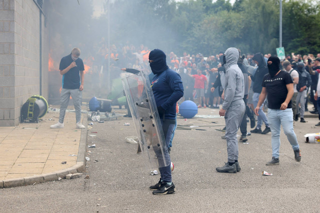 Seorang demonstran memegang perisai selama protes anti-imigrasi, di Rotherham, Inggris, Minggu (4/8/2024). Foto: Hollie Adams/REUTERS