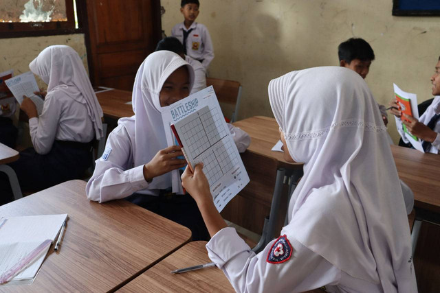 Siswa SMP Negeri 01 Kedu bermain Cartesian Battleship bersama teman sebangku