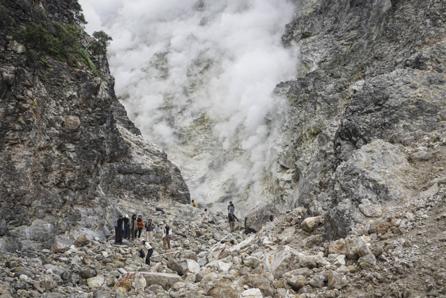 Pengunjung melihat asap dan belerang yang keluar dari dinding kawah Candradimuka di Gunung Lawu, Tawangmangu, Karanganyar, Jawa Tengah, Senin (5/8/2024). Foto: Mohammad Ayudha/ANTARA FOTO