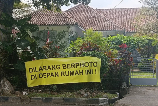 Spanduk larangan berfoto terpasang di depan rumah yang dijadikan syuting film Dilan 1990 di Bandung, Selasa (6/8/2024). Foto: Robby Bouceu/kumparan