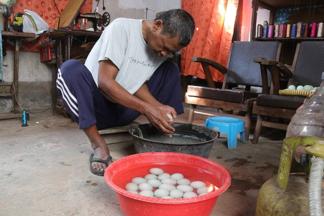 Wasijan (55) saat saat membersihkan telur bebek di rumahnya yang berada di Jalan Kembang Basen RT 13 RW 04 KG III/240, Kelurahan Purbayan, Kemantren Kotagede, Yogyakarta, Senin (5/8). Foto: Pemkot Yogya