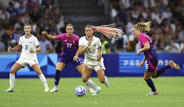 Trinity Rodman dari Amerika Serikat beraksi dengan Janina Minge dari Jerman dan Klara Buehl dari Jerman pada Olimpiade Paris 2024 di Stadion Marseille, Marseille, Prancis (28/7/2024). Foto: Luisa Gonzalez/REUTERS 