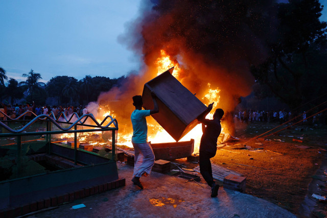 Demonstran membakar furnitur yang dijarah dari kediaman Perdana Menteri Bangladesh Sheikh Hasina di Dhaka, Bangladesh, Senin (5/8/2024). Foto: Mohammad Ponir Hossain/REUTERS 