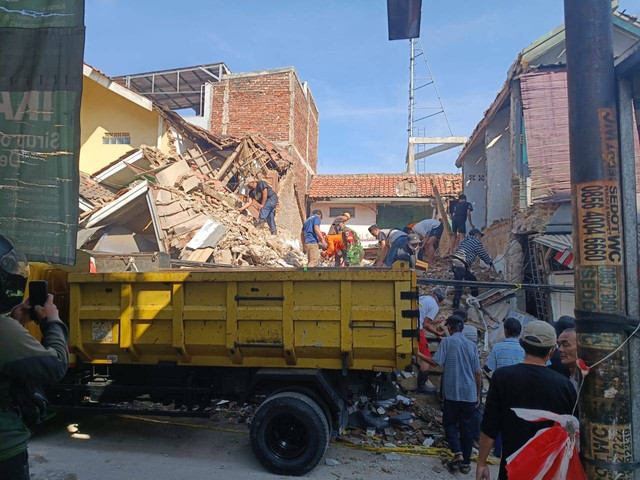 Warga bersama petugas gabungan melanjutkan proses pembersihan puing rumah ambruk di Jalan Sampora Desa Sukamenak, Kecamatan Margahayu, Kabupaten Bandung, pada Rabu (7/8). Foto: Robby Bouceu/kumparan