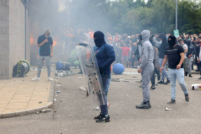 Seorang demonstran memegang perisai selama protes anti-imigrasi, di Rotherham, Inggris, Minggu (4/8/2024). Foto: Hollie Adams/REUTERS/Kumparan