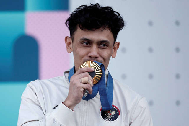 Atlet panjat tebing putra Indonesia Veddriq Leonardo mencium medali emas yang diraih usai mengalahkan atlet China Wu Peng pada final nomor speed putra Olimpiade Paris 2024 di Le Bourget Climbing Venue, Paris, Prancis, Kamis (8/8/2024).  Foto: Beonit Tressor/Reuters