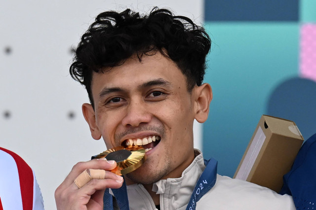 Atlet panjat tebing putra Indonesia Veddriq Leonardo menggigit medali emas usai juara dalam nomor speed putra Olimpiade Paris 2024 di Le Bourget Climbing Venue, Paris, Prancis, Kamis (8/8/2024). Foto: Wahyu Putro A/ANTARA FOTO