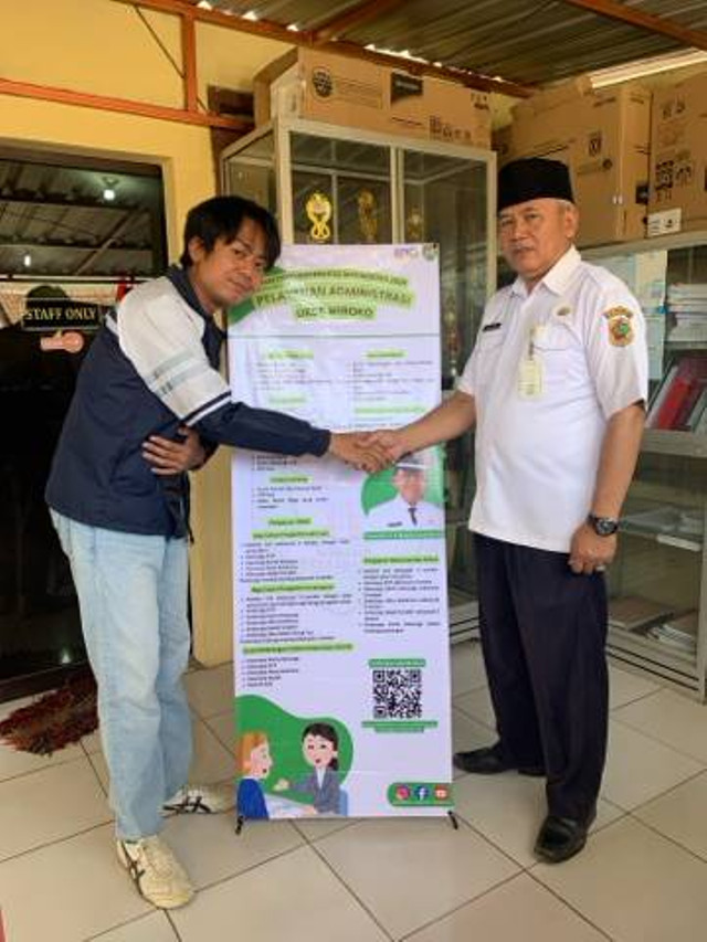 Penyerahan infografis berupa standing banner berisikan informasi persyaratan layanan administratif Desa Wiroko (07/08/2024) (Sumber: Dokumen Pribadi).