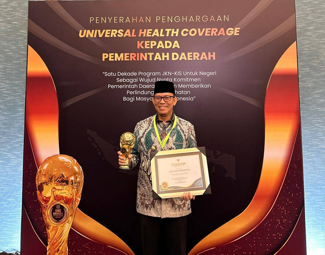 Pj Bupati OKU Teddy Meilwansyah saat menerima penghargaan Universal Healt Coverage (UHC) award dari Wakil Presiden RI KH Ma'ruf Amin, Foto : Kominfo Pemkab OKU