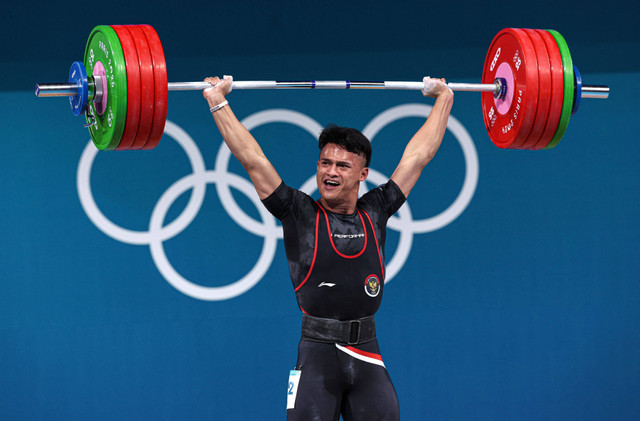 Rizki Juniansyah beraksi di cabor angkat besi Olimpiade Paris 2024. Foto: REUTERS/Amanda Perobelli