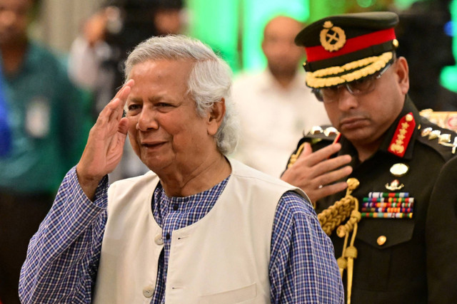 Pemenang Hadiah Nobel Perdamaian Muhammad Yunus kiri) diambil sumpahnya dalam upacara pengambilan sumpah untuk memimpin pemerintahan sementara Bangladesh di Dhaka, Kamis (8/8/2024). Foto: Munir Uz zaman/AFP