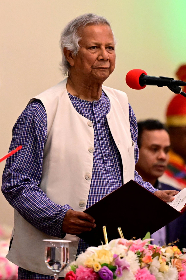 Pemenang Hadiah Nobel Perdamaian Muhammad Yunus kiri) berpidato dalam upacara pengambilan sumpah untuk memimpin pemerintahan sementara Bangladesh di Dhaka, Kamis (8/8/2024). Foto:  Munir Uz zaman/AFP