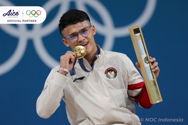 Lifter Indonesia Rizki Juniansyah berpose dengan medali emasnya usai upacara pengalungan medali kelas 73 kg putra Olimpiade Paris 2024 di South Paris Arena, Paris, Prancis, Kamis (8/8/2024). Foto: Dok. NOC Indonesia 