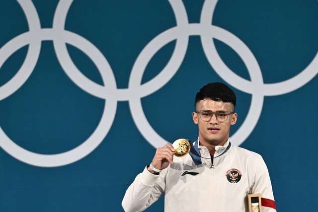 Lifter Indonesia Rizki Juniansyah berpose dengan medali emasnya usai upacara pengalungan medali kelas 73 kg putra Olimpiade Paris 2024 di South Paris Arena, Paris, Prancis, Kamis (8/8/2024). Foto: Wahyu Putro A/ANTARA FOTO