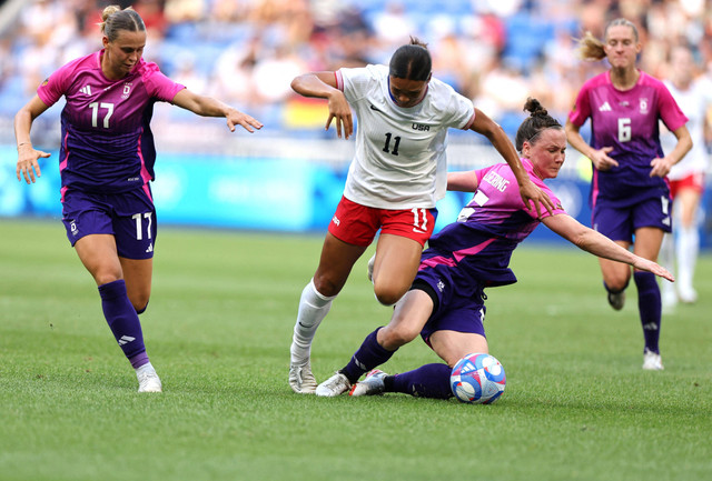 Sophia Smith (putih) berusaha melewati adangan Klara Buehl dan Marina Hegering dari Jerman (ungu).  Foto: NIR ELIAS/Reuters