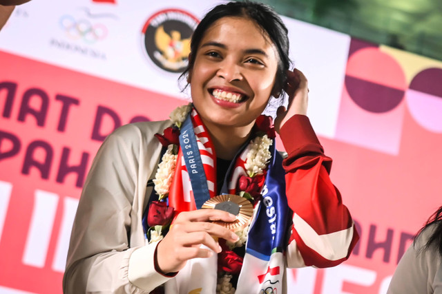 Pebulu tangkis Gregoria Mariska Tunjung menunjukkan medali perunggu yang diraihnya setibanya di Terminal 3 Bandara Soekarno Hatta, Kota Tangerang, Banten, Jumat (9/8/2024). Foto: Sulthony Hasanuddin/ANTARA FOTO 