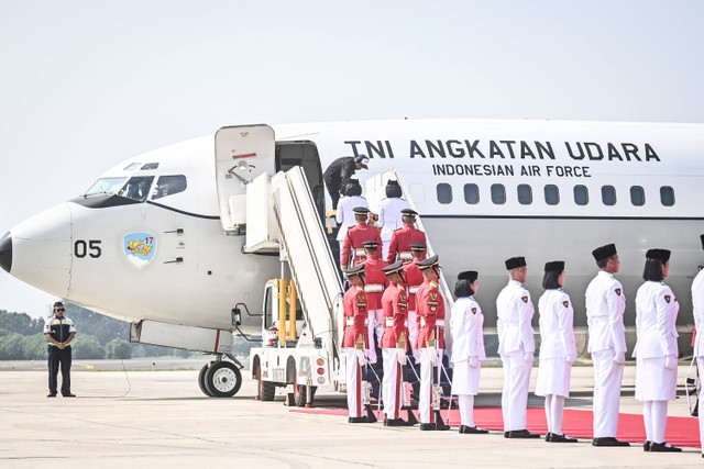 Tim Purna Paskibraka 2023 membawa duplikat bendera Merah Putih dan naskah teks proklamasi berjalan masuk ke pesawat TNI AU dalam acara kirab HUT ke-79 RI di Lanud Halim Perdana Kusuma, Jakarta, Sabtu (10/8/2024). Foto: Aprillio Akbar/ANTARA FOTO