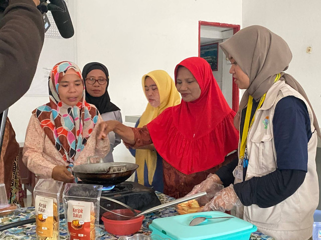 Sejumlah ibu-ibu PKK di Bunaken sedang membuat keripik sukun bersama mahasiswa KKN UGM. Foto: Resti Damayanti/Pandangan Jogja