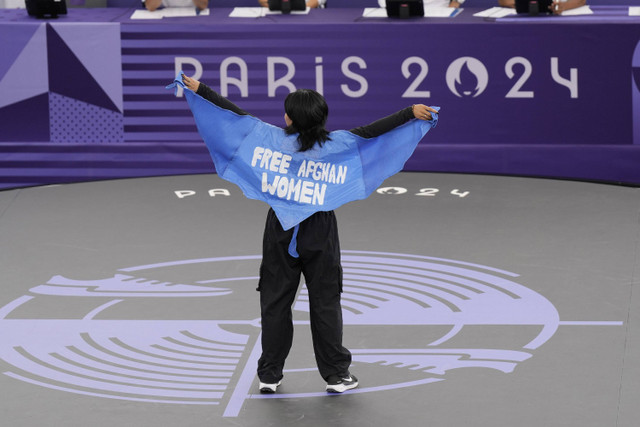 Manizha Talash dari Tim Pengungsi, mengenakan jubah bertuliskan "bebaskan wanita Afghanistan" saat bertanding dalam Pertarungan Pra-Kualifikasi B-Girls pada kompetisi pemecahan rekor di La Concorde Urban Park Olimpiade Paris 2024, Jumat (9/8/2024). Foto: Abbie Parr/AP Photo