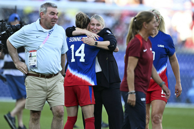 Gelandang AS Emily Sonnett dan pelatih Inggris AS Emma Hayes merayakan kemenangan mereka di akhir pertandingan sepak bola final medali emas putri antara Brasil dan AS selama Olimpiade Paris 2024 di Parc des Princes, Paris, Sabtu (10/8/2024). Foto: Patricia De Melo Moreira/AFP