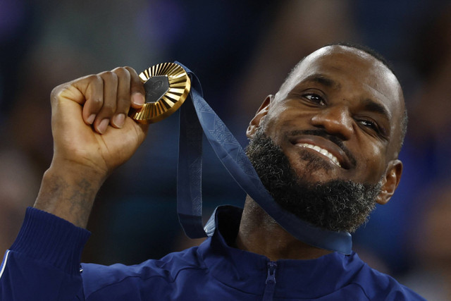 Peraih medali emas Lebron James dari Amerika Serikat berpose dengan medalinya dalam Olimpiade Paris 2024 di Bercy Arena, Paris, Prancis, Sabtu (10/8/2024). Foto: Evelyn Hockstein/REUTERS 