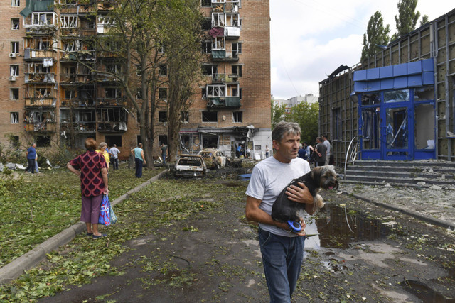 Penghuni gedung apartemen yang rusak setelah ditembaki oleh pihak Ukraina meninggalkan daerah tersebut di Kursk, Rusia, Minggu (11/8/2024). Foto: AP Photo