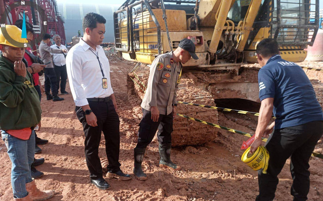 Polisi saat memeriksa tempat kejadian perkara. Pekerja di PT BAI kembali alami kecelakaan, meninggal usai terlindas excavator. Foto: Muhammad Zain/Hi!Pontianak