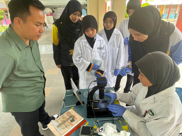 Achmad Syafiuddin, Ph.D., Ketua Pengabdian Masyarakat Internasional Unusa (kemeja hijau) saat memberikan edukasi kepada siswa SD di Mallaysia. Foto: Humas Unusa