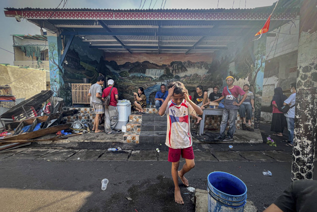 Sejumlah warga menatap sisa rumahnya yang terbakar di kawasan Manggarai, Jakarta, Selasa (13/8/2024). Foto: Iqbal Firdaus/kumparan