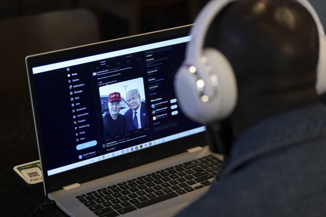 Seseorang menonton di laptop wawancara pengusaha miliarder Elon Musk dengan kandidat presiden dari Partai Republik dan mantan Presiden AS Donald Trump di jaringan media sosial X, di New York City, AS, Senin (12/8/2024). Foto: Adam Gray/REUTERS