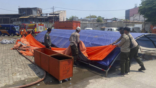 Proses pembangunan tenda pengungsi untuk warga terdampak kebakaran di Manggarai pada Selasa (13/8/2024). Foto: Abid Raihan/kumparan