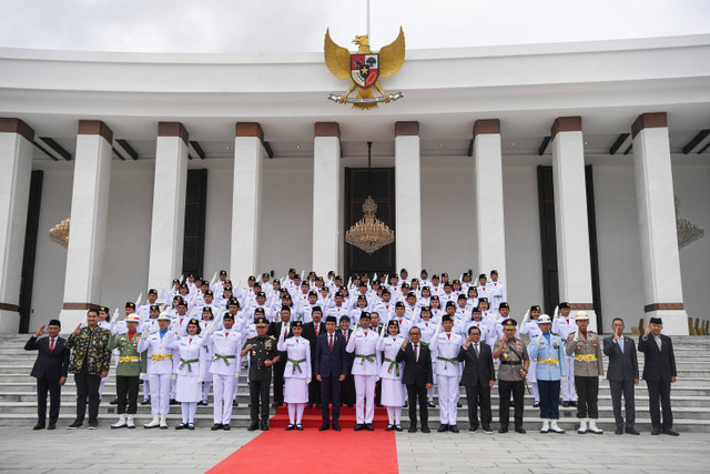 Presiden Joko Widodo (tengah) didampingi sejumlah menteri dan kepala lembaga negara berfoto bersama anggota Paskibraka 2024 seusai dikukuhkan di Istana Negara, Ibu Kota Nusantara (IKN), Kalimantan Timur, Selasa (13/8/2024). Foto: Sigid Kurniawan/ANTARA FOTO 