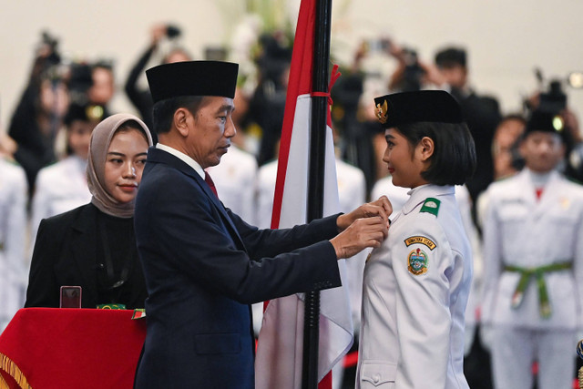 Presiden Joko Widodo menyematkan lencana kepada anggota Paskibraka 2024 asal Sumatera Utara Violetha Agryka Sianturi dalam pengukuhan Paskibraka Tingkat Pusat 2024 di Istana Negara, Ibu Kota Nusantara (IKN), Kalimantan Timur, Selasa (13/8/2024). Foto: Sigid Kurniawan/ANTARA FOTO 