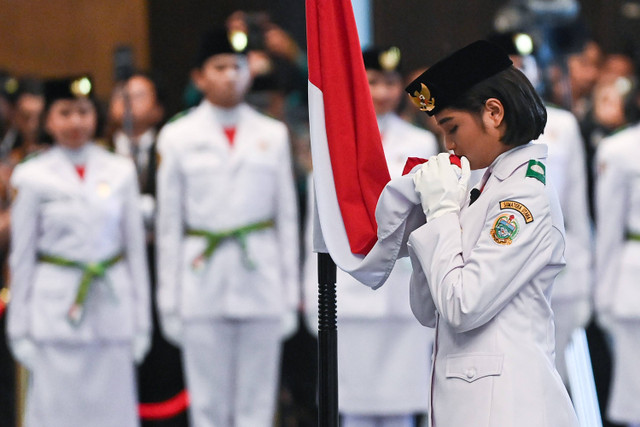 Anggota Paskibraka 2024 asal Sumatera Utara Violetha Agryka Sianturi mencium Bendera Merah-Putih dalam pengukuhan Paskibraka Tingkat Pusat 2024 di Istana Negara, Ibu Kota Nusantara (IKN), Kalimantan Timur, Selasa (13/8/2024). Foto: Sigid Kurniawan/ANTARA FOTO 