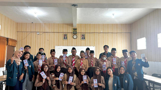 Foto bersama dengan Output Program Kerja yaitu leaflet.