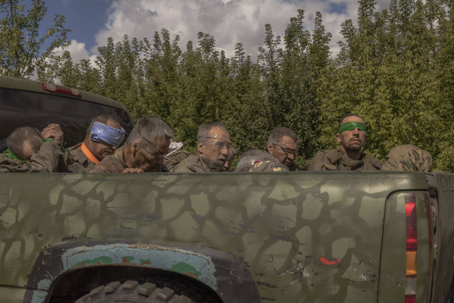 Sebuah kendaraan militer Ukraina melaju dari arah perbatasan dengan Rusia dengan membawa orang-orang yang ditutup matanya dengan seragam militer Rusia, di wilayah Sumy, Selasa (13/8/2024). Foto: Roman Pilipey/AFP