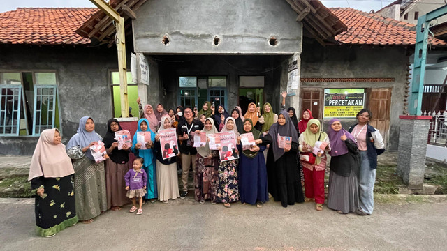 Foto bersama dengan ibu-ibu PKK RT 13 sembari memegang brosur dan produk ecoenzyme.