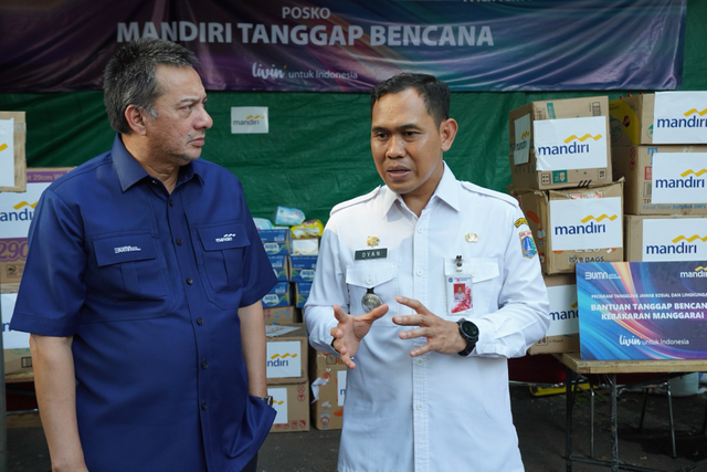 Corporate Secretary Bank Mandiri, Teuku Ali Usman (kiri) menyerahkan bantuan kepada korban kebakaran di Manggarai, Jakarta Selatan, Rabu (14/8/2024). Foto: Dok. Bank Mandiri