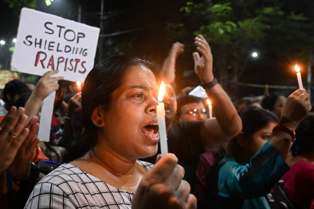 Para profesional medis dan aktivis memegang poster dan lilin ketika mereka mengambil bagian dalam protes tengah malam untuk mengutuk pemerkosaan dan pembunuhan seorang petugas medis muda, di Kolkata pada tanggal 14 Agustus 2024. Foto: Dibyangshu SARKAR/AFP