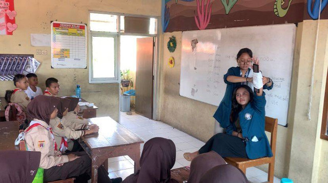 Demonstrasi pembalutan luka pada korban kecelakaan patah tulang tangan oleh KKN UNDIP kepada siswa-siswa SD Negeri 01 Pekuncen (Sumber Foto : Dokumentasi Pribadi)