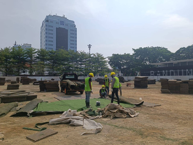 Proses revitalisasi rumput sintetis di area Taman Alun-alun Kota Bandung, pada Jumat (16/8/2024). Foto: Robby Bouceu/kumparan